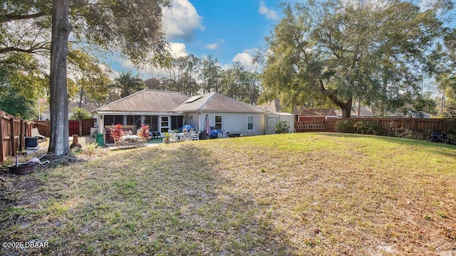 back of property with a lawn and a patio area