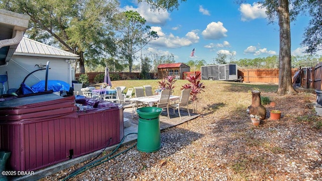 view of yard with a storage shed, a hot tub, and a patio