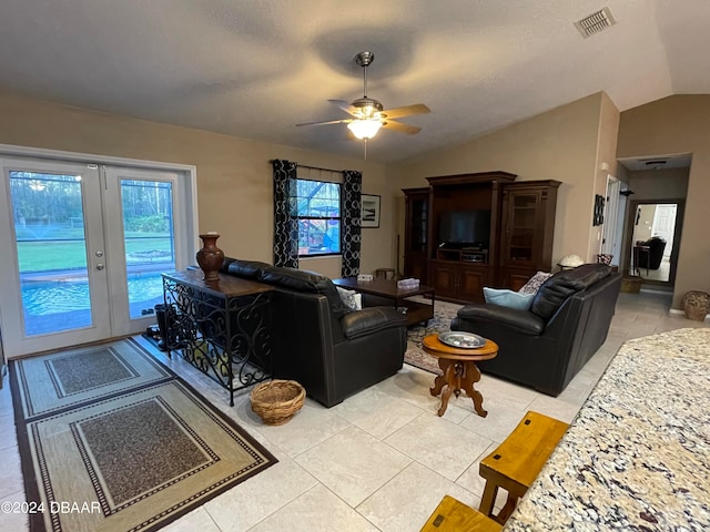 living room featuring ceiling fan, light tile patterned floors, and vaulted ceiling