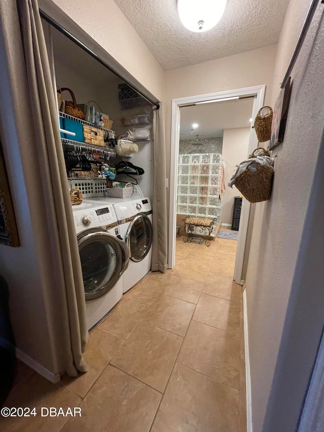 washroom featuring washer and clothes dryer, a textured ceiling, and light tile patterned flooring