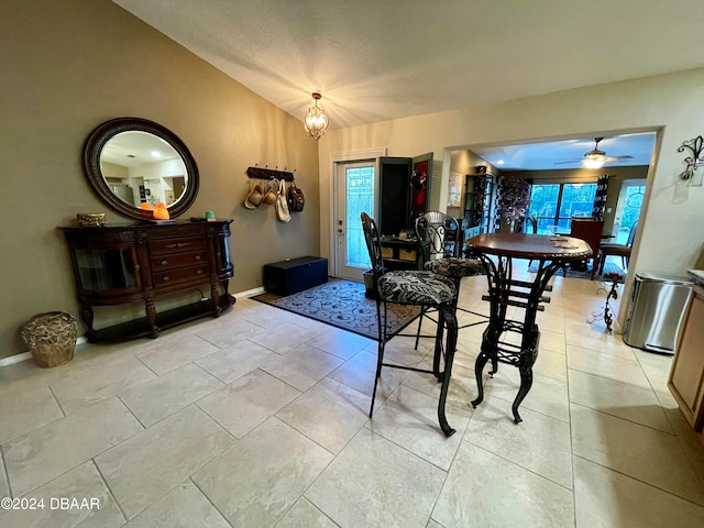 tiled dining space with a wealth of natural light and ceiling fan with notable chandelier