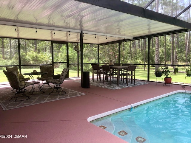 view of swimming pool with glass enclosure and a patio