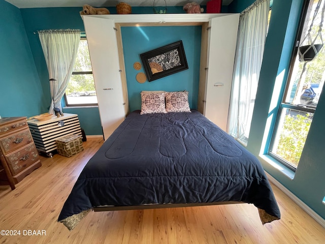 bedroom featuring multiple windows and light hardwood / wood-style flooring