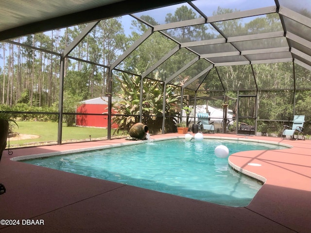 view of swimming pool featuring glass enclosure and a patio area