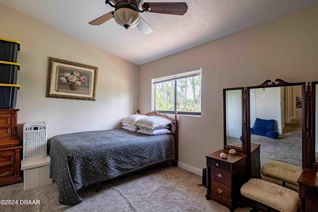 bedroom with ceiling fan, a textured ceiling, vaulted ceiling, and light colored carpet