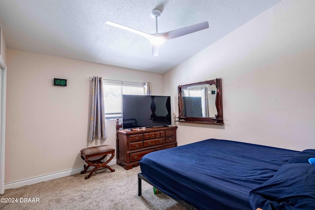 carpeted bedroom with a textured ceiling, lofted ceiling, and ceiling fan