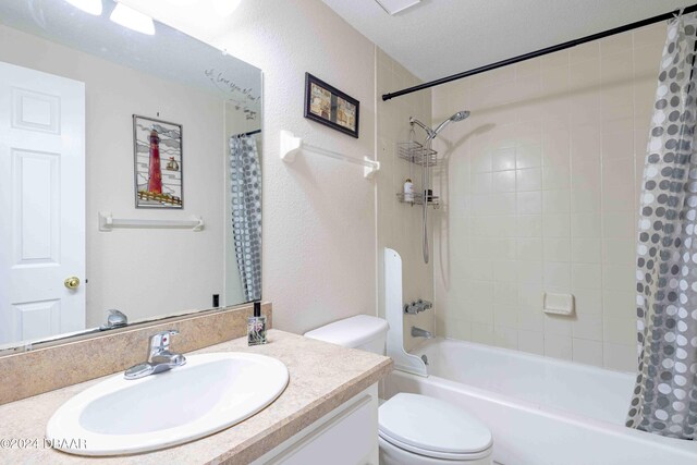 full bathroom featuring vanity, a textured ceiling, toilet, and shower / bathtub combination with curtain