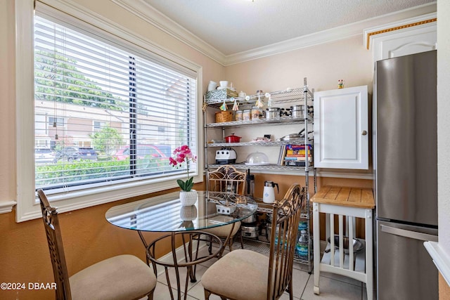 dining area with a textured ceiling, light tile patterned floors, a healthy amount of sunlight, and crown molding