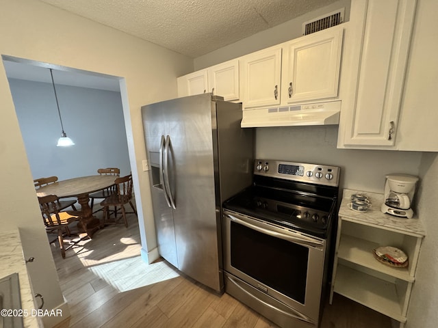 kitchen featuring stainless steel appliances, light countertops, visible vents, light wood-style flooring, and under cabinet range hood