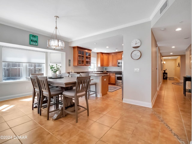 dining space with sink, light tile patterned floors, crown molding, and a chandelier