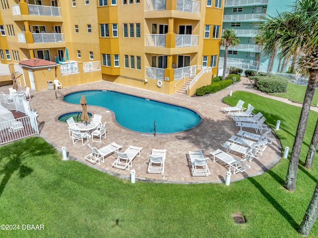 view of swimming pool featuring a lawn and a patio area