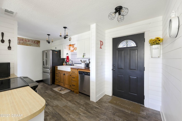 kitchen featuring sink, dark wood-type flooring, a chandelier, white cabinets, and appliances with stainless steel finishes