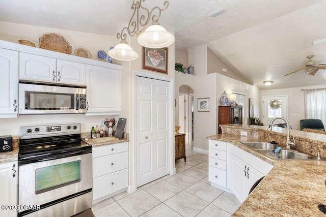 1465 Admiral Nimitz Ave, Daytona Beach, FL 32124 - kitchen featuring stainless steel appliances, a sink, arched walkways, light tile patterned flooring, and white cabinets