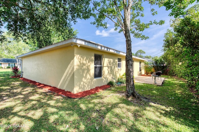 1465 Admiral Nimitz Ave, Daytona Beach, FL 32124 - view of property exterior featuring stucco siding, a patio area, and a yard