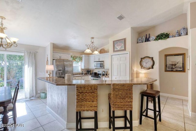 1465 Admiral Nimitz Ave, Daytona Beach, FL 32124 - kitchen featuring stainless steel appliances, a chandelier, plenty of natural light, a breakfast bar, and lofted ceiling