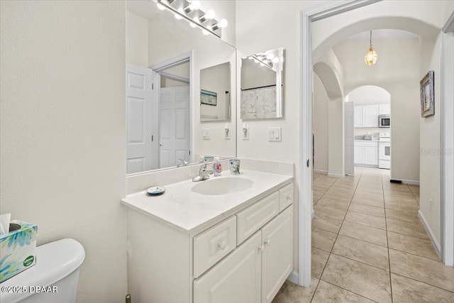 bathroom featuring tile patterned flooring, vanity, toilet, and baseboards