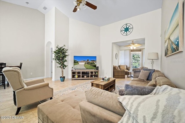 living area with arched walkways, high vaulted ceiling, light tile patterned floors, and visible vents