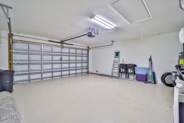 garage featuring concrete block wall and a garage door opener