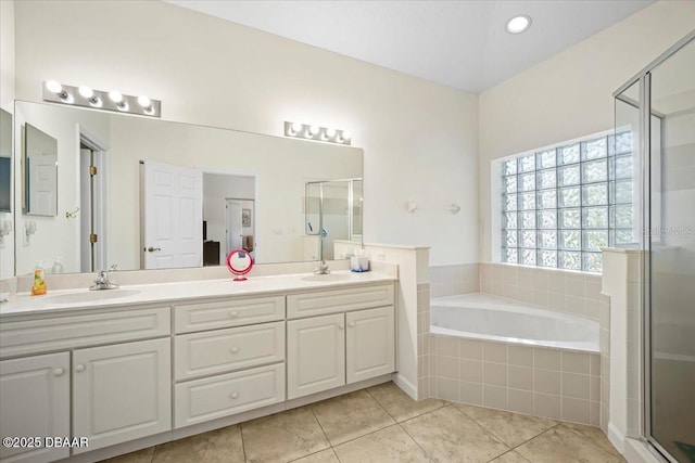 full bathroom with a stall shower, a sink, a bath, and tile patterned floors