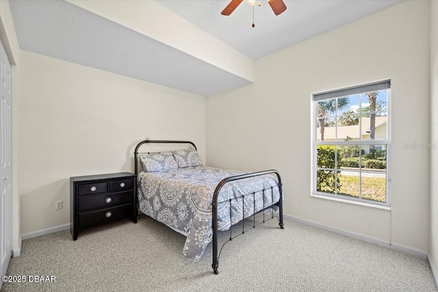 bedroom with baseboards, a ceiling fan, and light colored carpet