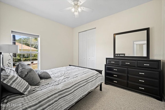 bedroom with ceiling fan, a closet, and light colored carpet