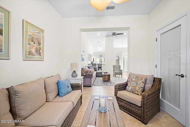 living room featuring light tile patterned floors, ceiling fan, visible vents, and arched walkways