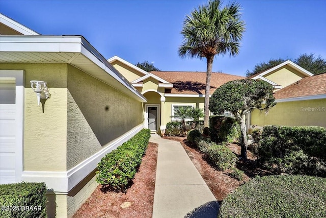 property entrance with an attached garage and stucco siding