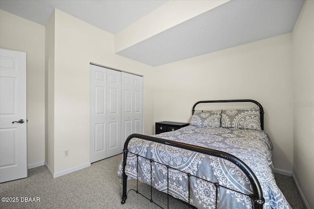 carpeted bedroom featuring a closet and baseboards