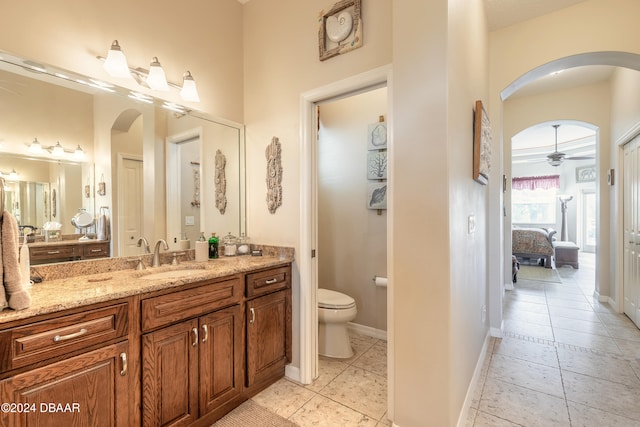 bathroom with tile patterned flooring, vanity, ceiling fan, and toilet