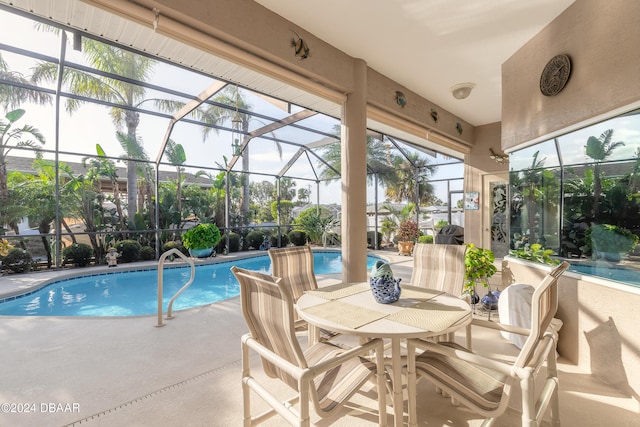 view of pool featuring glass enclosure and a patio area