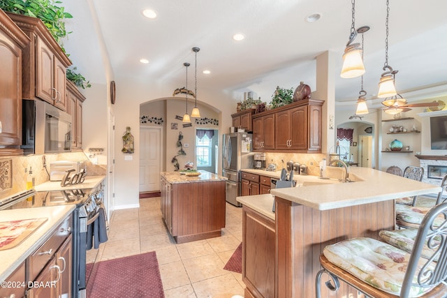 kitchen with pendant lighting, a center island, kitchen peninsula, and appliances with stainless steel finishes