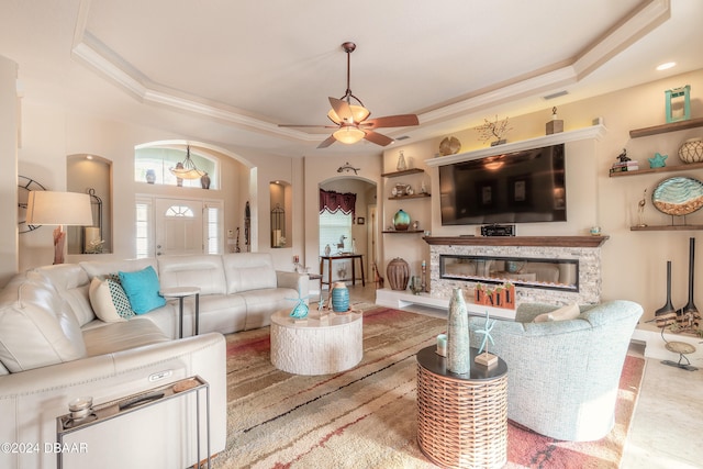 living room with a tray ceiling and ceiling fan