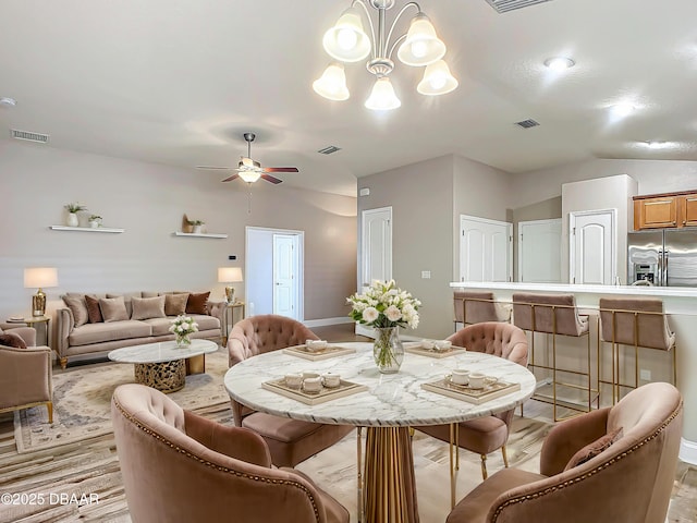 dining space with ceiling fan with notable chandelier and lofted ceiling