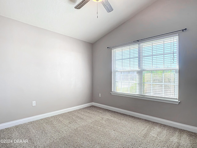 spare room featuring lofted ceiling, carpet, ceiling fan, and a healthy amount of sunlight