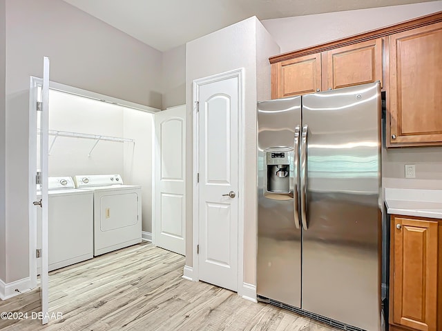 kitchen featuring light hardwood / wood-style floors, stainless steel fridge with ice dispenser, and washing machine and dryer