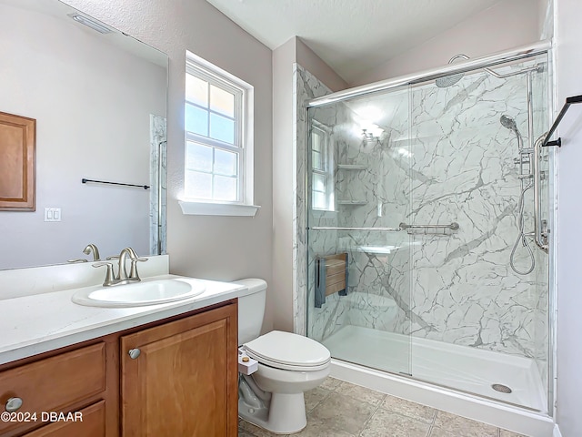 bathroom with toilet, a shower with door, and vanity