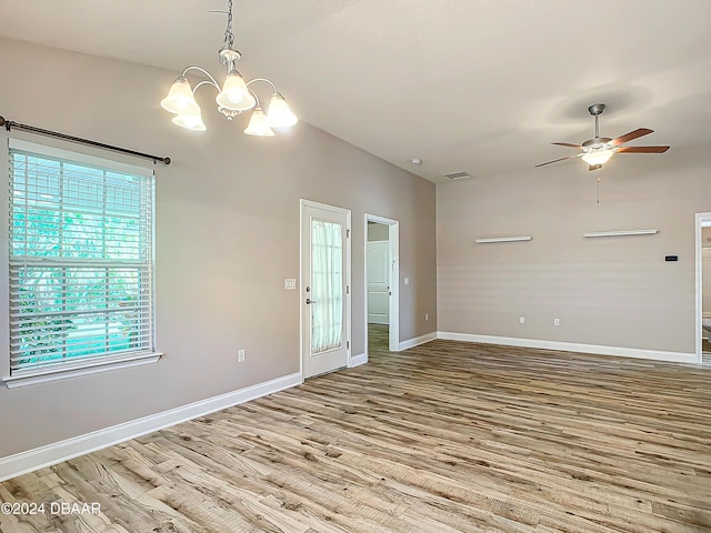 unfurnished room with light hardwood / wood-style floors and ceiling fan with notable chandelier