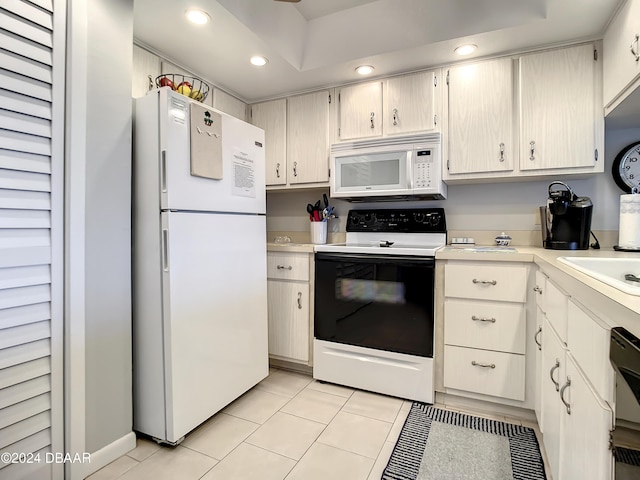 kitchen with white appliances, sink, and light tile patterned floors