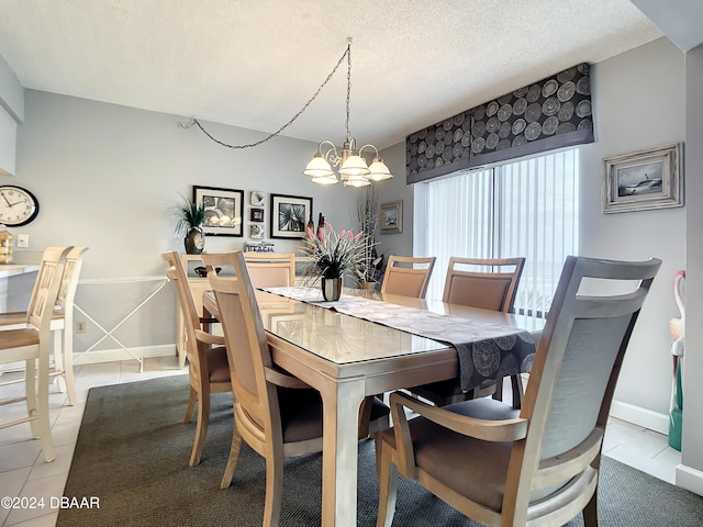 dining space featuring light tile patterned floors, a textured ceiling, and an inviting chandelier