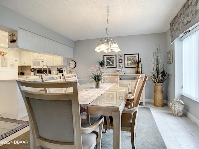 tiled dining area featuring a textured ceiling and an inviting chandelier