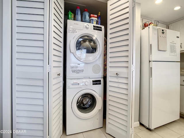 clothes washing area featuring stacked washer / drying machine and light tile patterned floors