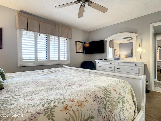 bedroom with ceiling fan and a textured ceiling