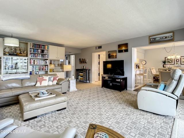 living room with a textured ceiling, light carpet, and a chandelier