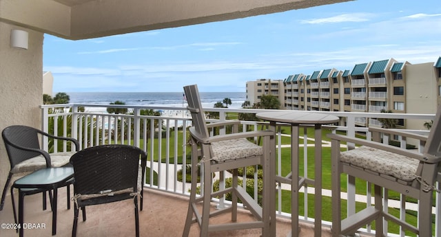 balcony featuring a water view and a beach view