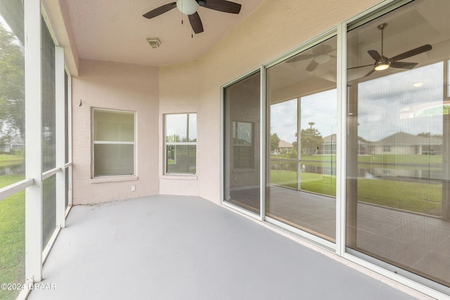 unfurnished sunroom with ceiling fan