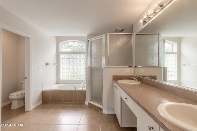 full bathroom featuring toilet, plus walk in shower, vanity, and tile patterned flooring