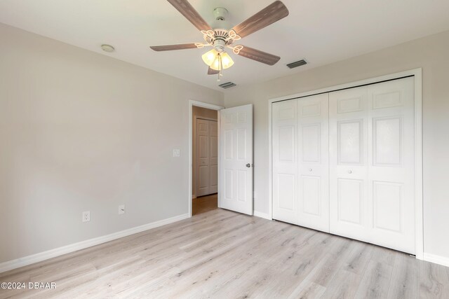 unfurnished bedroom with a closet, light hardwood / wood-style floors, and ceiling fan