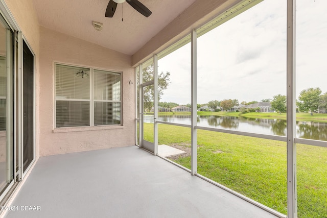 unfurnished sunroom featuring a water view, ceiling fan, and lofted ceiling