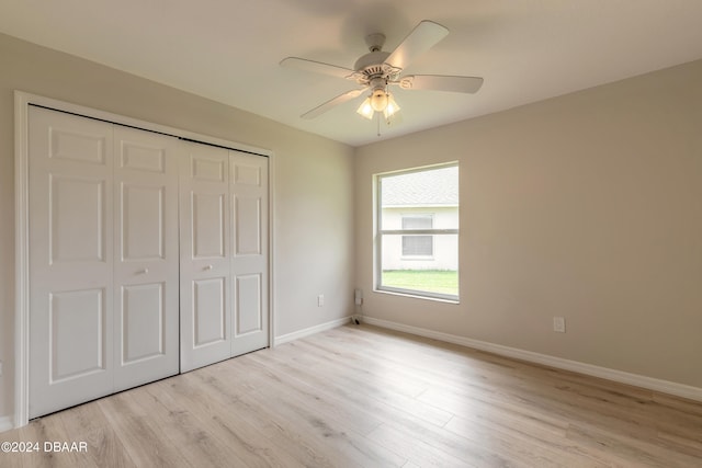 unfurnished bedroom with light hardwood / wood-style flooring, ceiling fan, and a closet