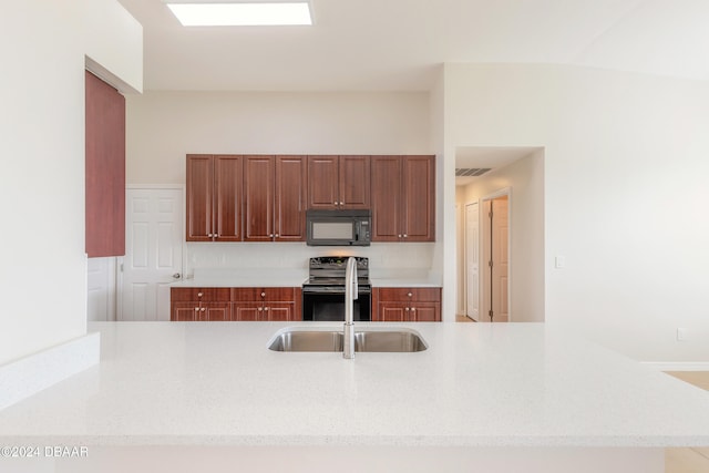 kitchen featuring kitchen peninsula, stainless steel range with electric cooktop, and sink